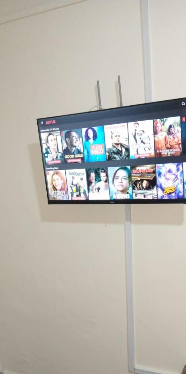 Un televisor montado en la pared muestra una selección de series de Netflix.
