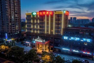 A multi-story hotel with a prominent entrance and illuminated signage.