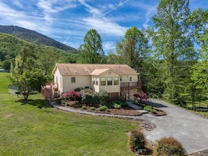 A single-story house with a front porch, a driveway, and a well-maintained lawn.