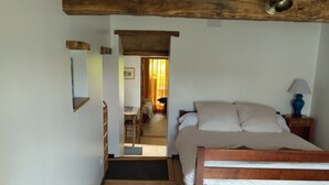 A bedroom with a bed, a bedside table, a lamp, and a wooden ceiling. - Charming Gîte (4 people) ideal for couples or families, near Montcuq
 (PORTE DU QUERCY)