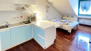 A compact, modern apartment with a kitchen, a small dining area, and a bedroom. - Casa Mirtillo (Turin)