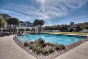 Relax by the pool surrounded by lush greenery and comfortable lounge chairs.