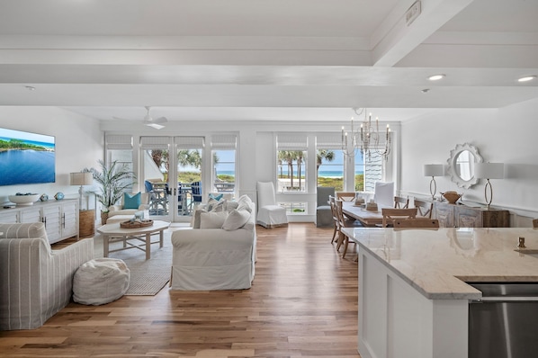Enjoy ocean views from the living area, featuring a large TV and dining table.