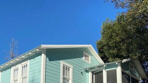 Een tweelaags huis met een veranda, een trap en een overdekt terras.