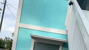 Een gebouw met een turquoise gevel en een donkergrijze deur waarop het woord 'countryside' staat.