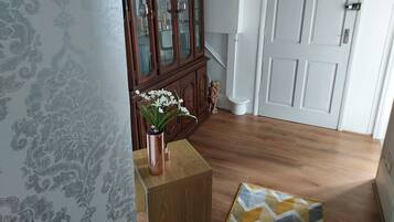 A room with a wooden cabinet, a white door, and a patterned wall.
