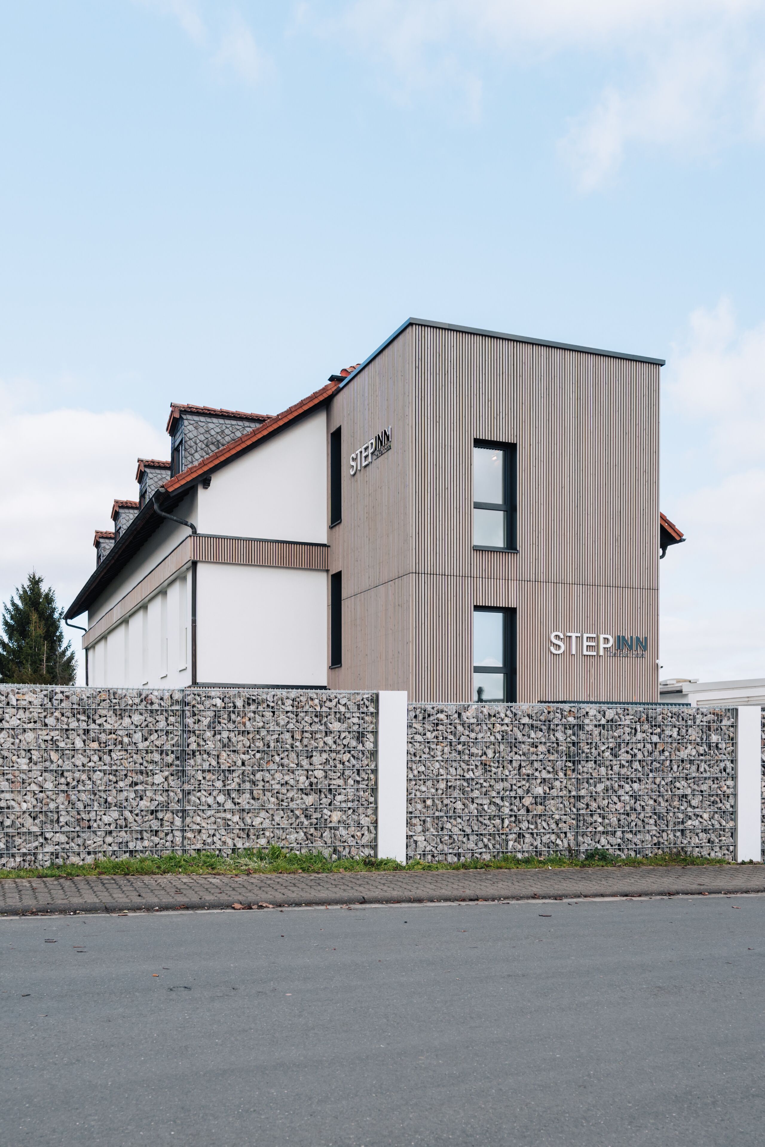 Un hotel moderno con fachada de piedra y un letrero que dice "STEPINN".