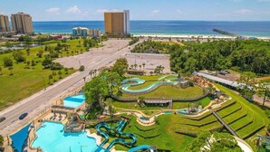 Ein Resort mit großem Pool, Wasserrutschen und Blick auf den Strand.