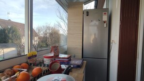 Una cocina moderna con un ventanal grande, un refrigerador y una encimera de madera con diversos objetos.