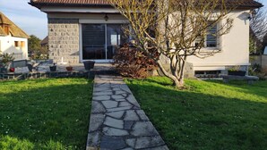 Una casa con fachada de piedra, techo de tejas y un camino de piedra que lleva a la entrada.