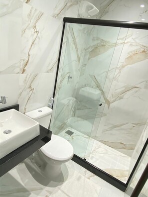 Quarto duplo conforto | Banheiro | Chuveiro, chuveiro com efeito de chuva, sabonete, papel higiênico