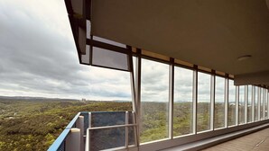 A balcony with a view of a forested landscape.