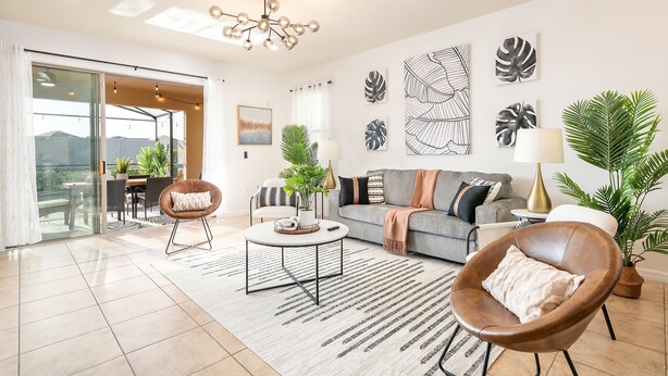 Uma sala de estar moderna com sofá, poltrona, mesa de centro e plantas decorativas.