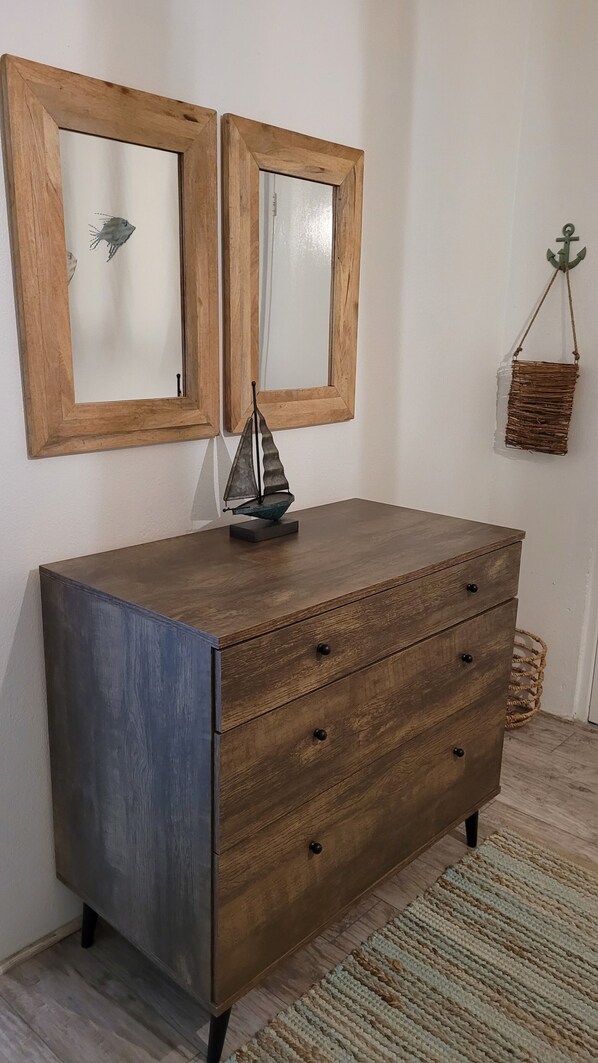 Un aparador de madera con cajones y una decoración de velero en la parte superior.