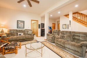A living room with two large sofas, a coffee table, a wooden side table, and a fireplace.
