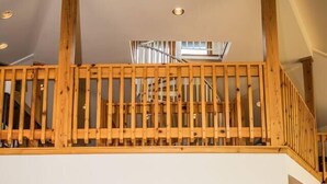 Un loft spacieux avec un escalier en bois, un coin repas et un espace salon confortable.