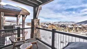 Un balcón con vistas a un pueblo cubierto de nieve y montañas.
