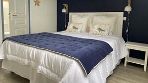 A bedroom with a bed, two nightstands, a wall-mounted lamp, and star decorations. - Port du Crouesty. duplex rénové, calme, terrasse, idéal en famille (6 pers) (Arzon)