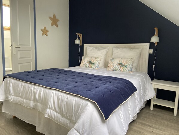 A bedroom with a bed, two nightstands, a wall-mounted lamp, and star decorations.