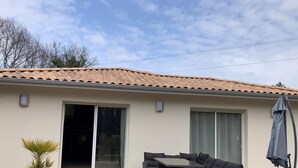 A patio area with a dining set and a potted plant. - Villa 3 bedrooms 900 m from Lac de Parentis (Parentis-en-Born)