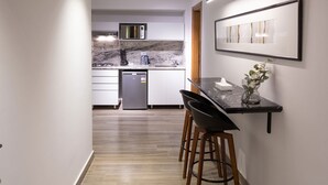 A modern kitchen with a microwave, stove, and dishwasher. There is a dining area with a table and chairs.