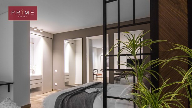 A modern bedroom with a bed, bedside tables, a mirror, and a potted plant.