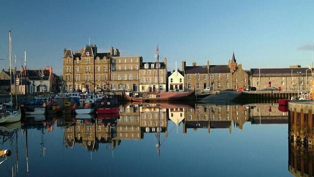 A harbor with boats and buildings reflecting on the water. - Kirkwall Hotel (Kirkwall)