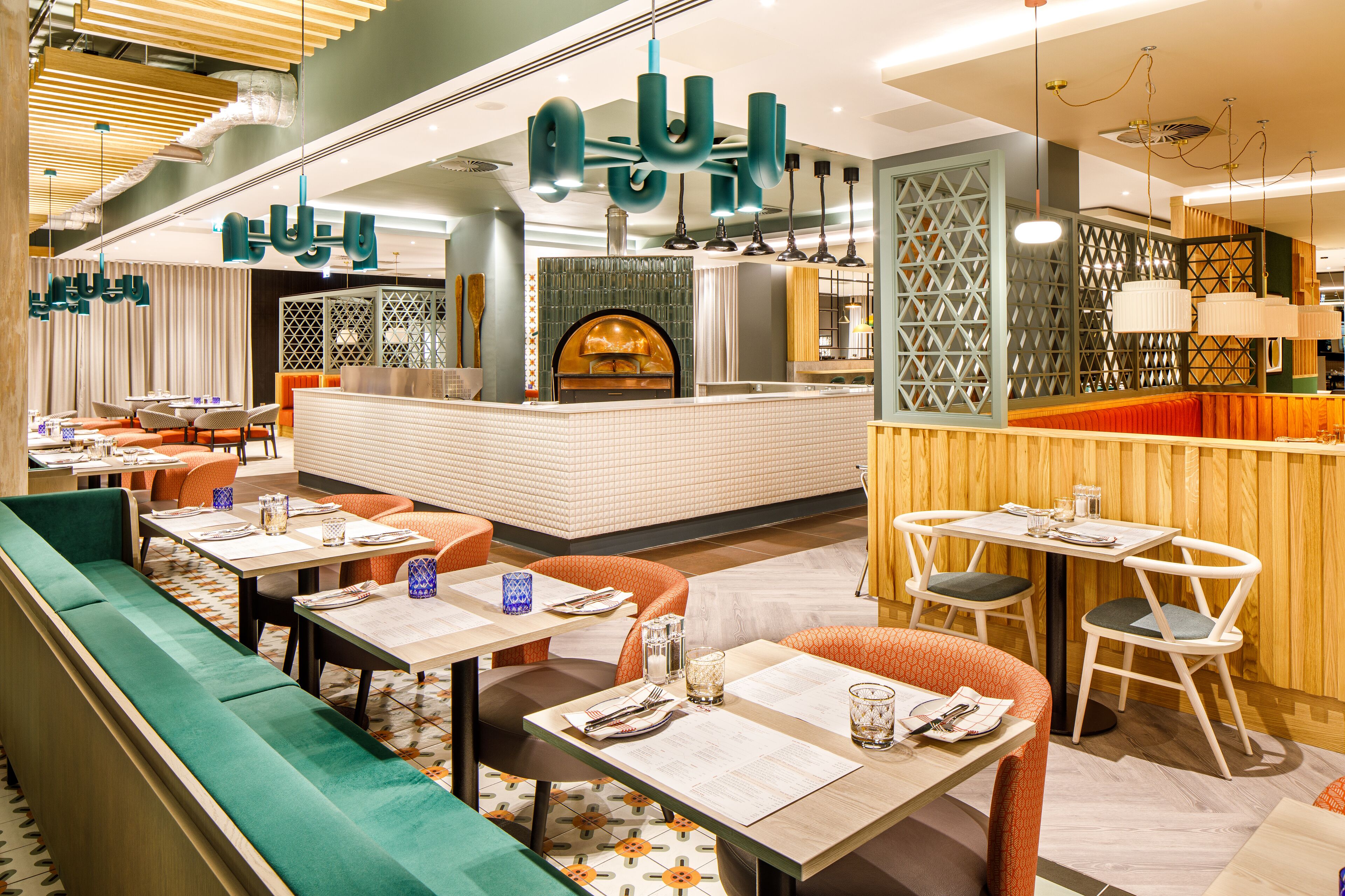 Un restaurant avec des banquettes, des tables et un coin bar.