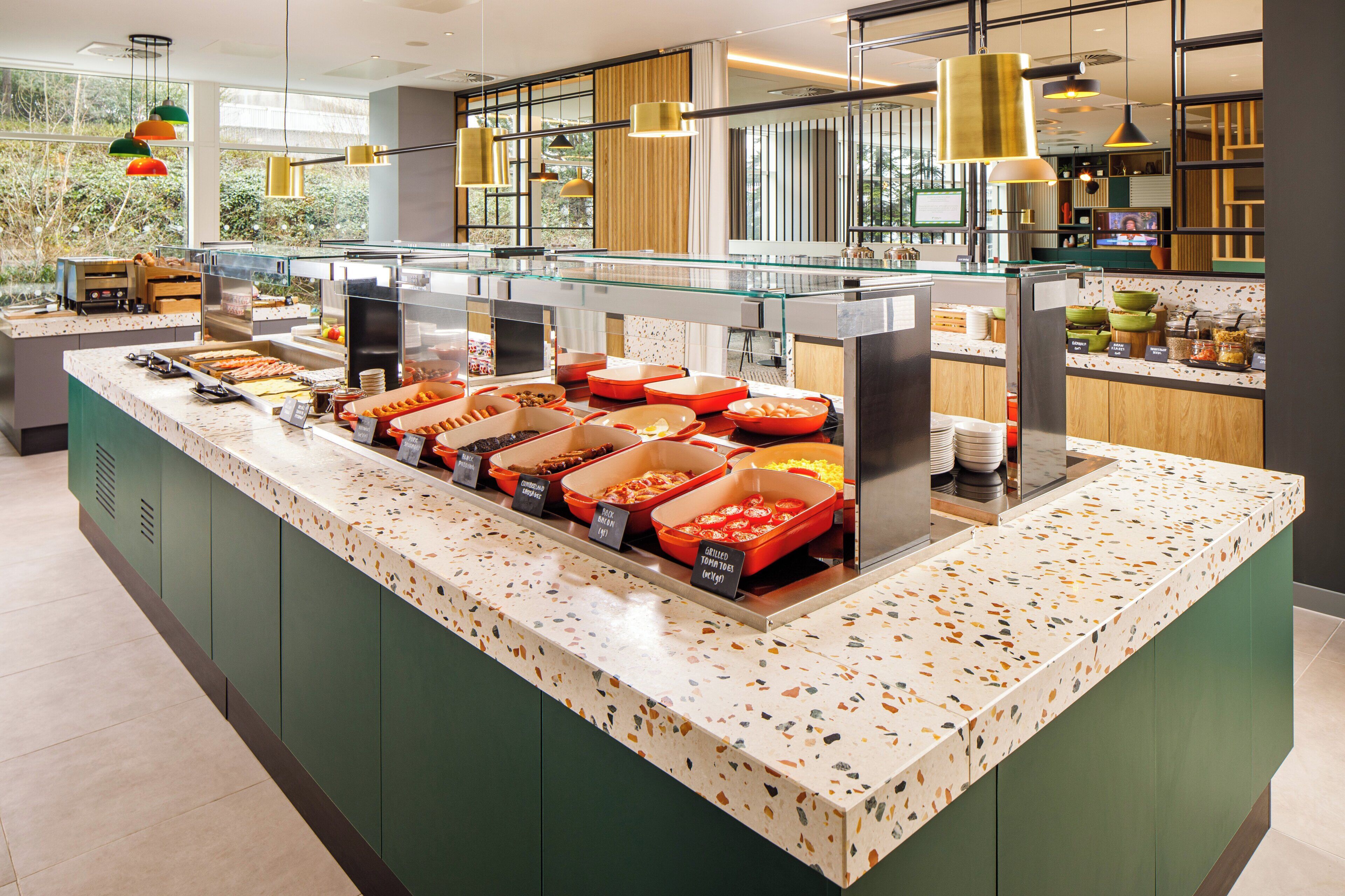 Buffet com diversas opções de comida e uma vitrine de vidro.