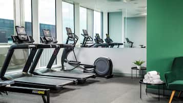 Ein Fitnessraum mit Laufbändern, Crosstrainern und einem stationären Fahrrad, ausgestattet mit Fitness-Trackern.