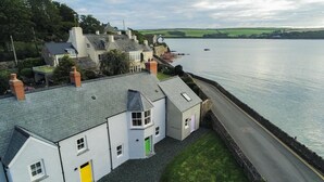 A coastal village with traditional houses, a paved road, and a body of water. - Brook Cottage Green - 2 Bedroom Cottage - Dale (Haverfordwest)