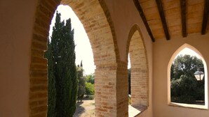 An interior corridor with arched brick walls and a window overlooking a garden. - I run away to Umbria, Monti (Umbria)