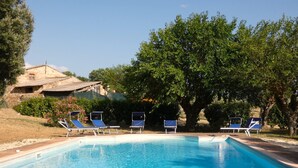 A rectangular swimming pool with clear blue water, surrounded by a paved deck. There are several lounge chairs aligned along the pool's edge. - I run away to Umbria, Monti (Umbria)