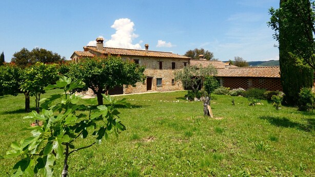 A stone building with a tiled roof, surrounded by a grassy field and trees. - I run away to Umbria, Monti (Umbria)