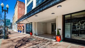 En hotellentrél med en överbyggd gång, stora fönster och en skylt som visar vägen till parkeringsplatsen på Jackson Avenue.