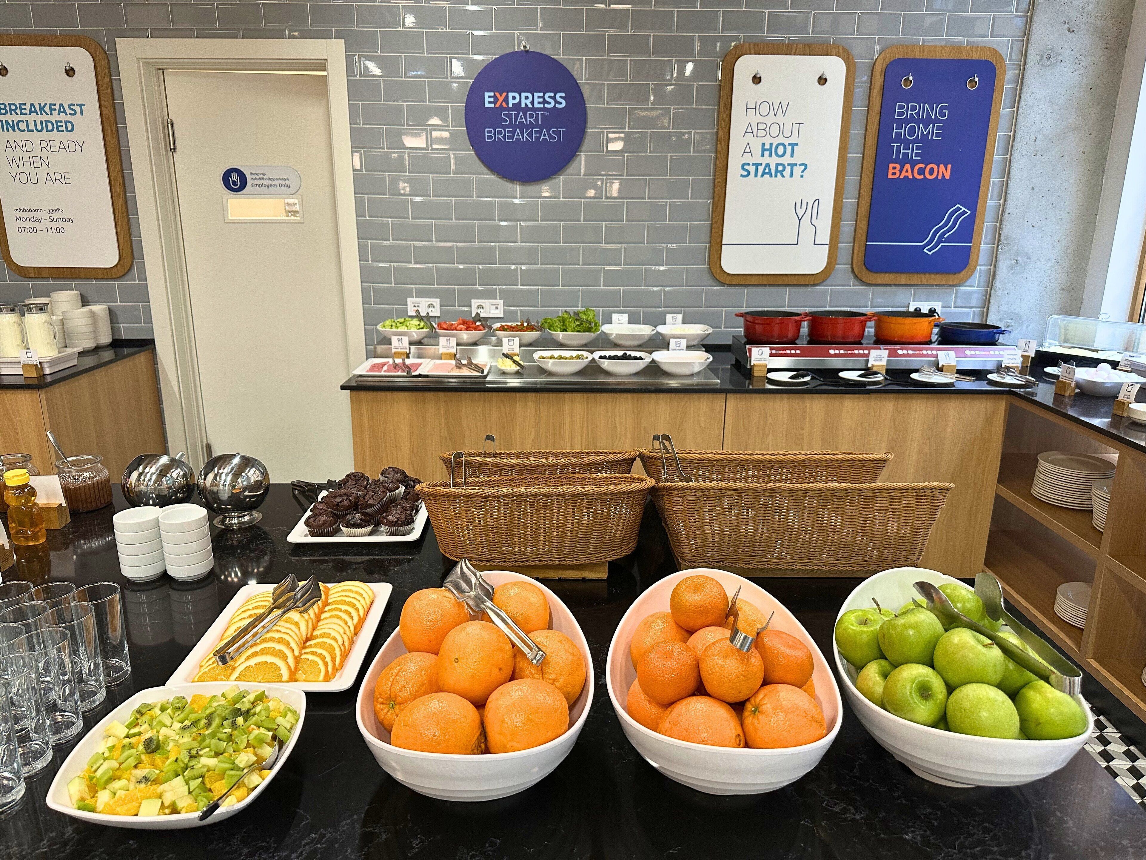 A breakfast buffet with various food items and a sign indicating breakfast is included.