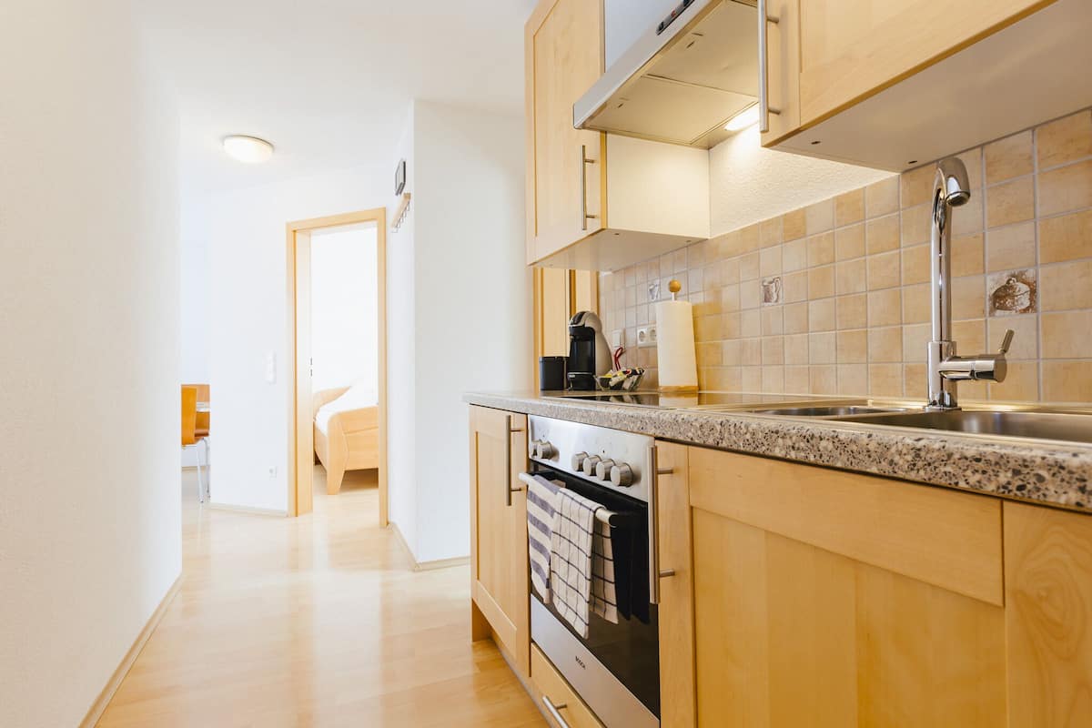 A modern kitchen with wooden cabinets, a stainless steel sink, and a built-in oven.