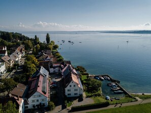 A lakeside residential area with houses, boats, and a clear view of the lake. - Strandpension Mäder (Uhldingen-Muehlhofen)