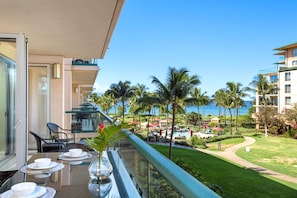 Tropical balcony bliss with ocean views and lush paradise below.