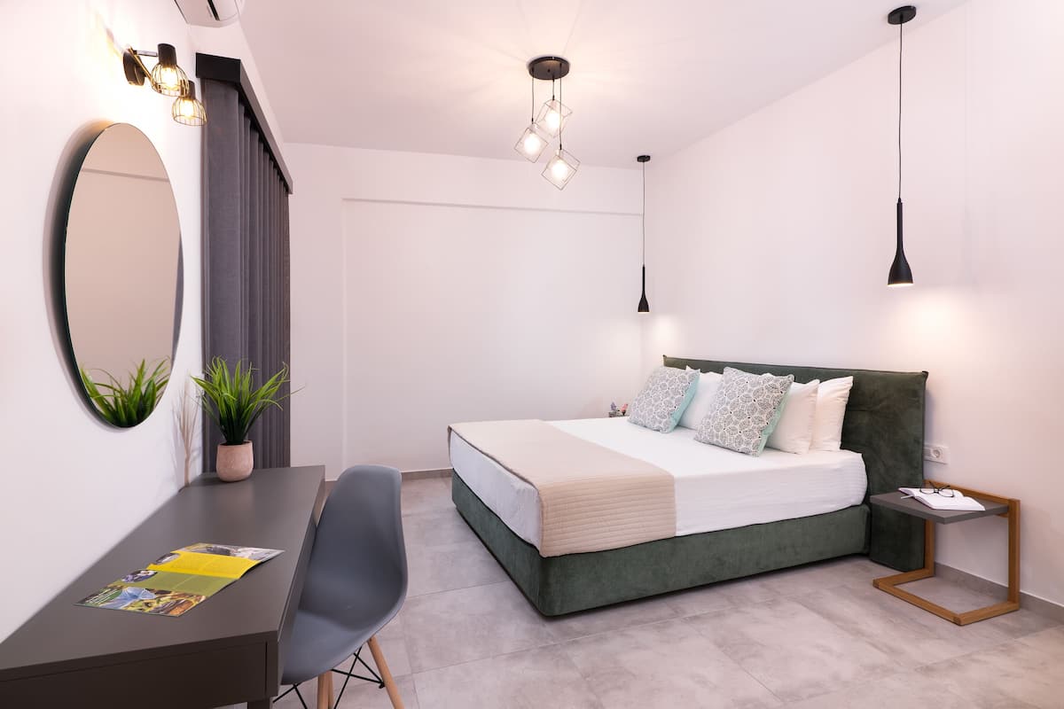 A modern bedroom with a bed, bedside table, and desk.