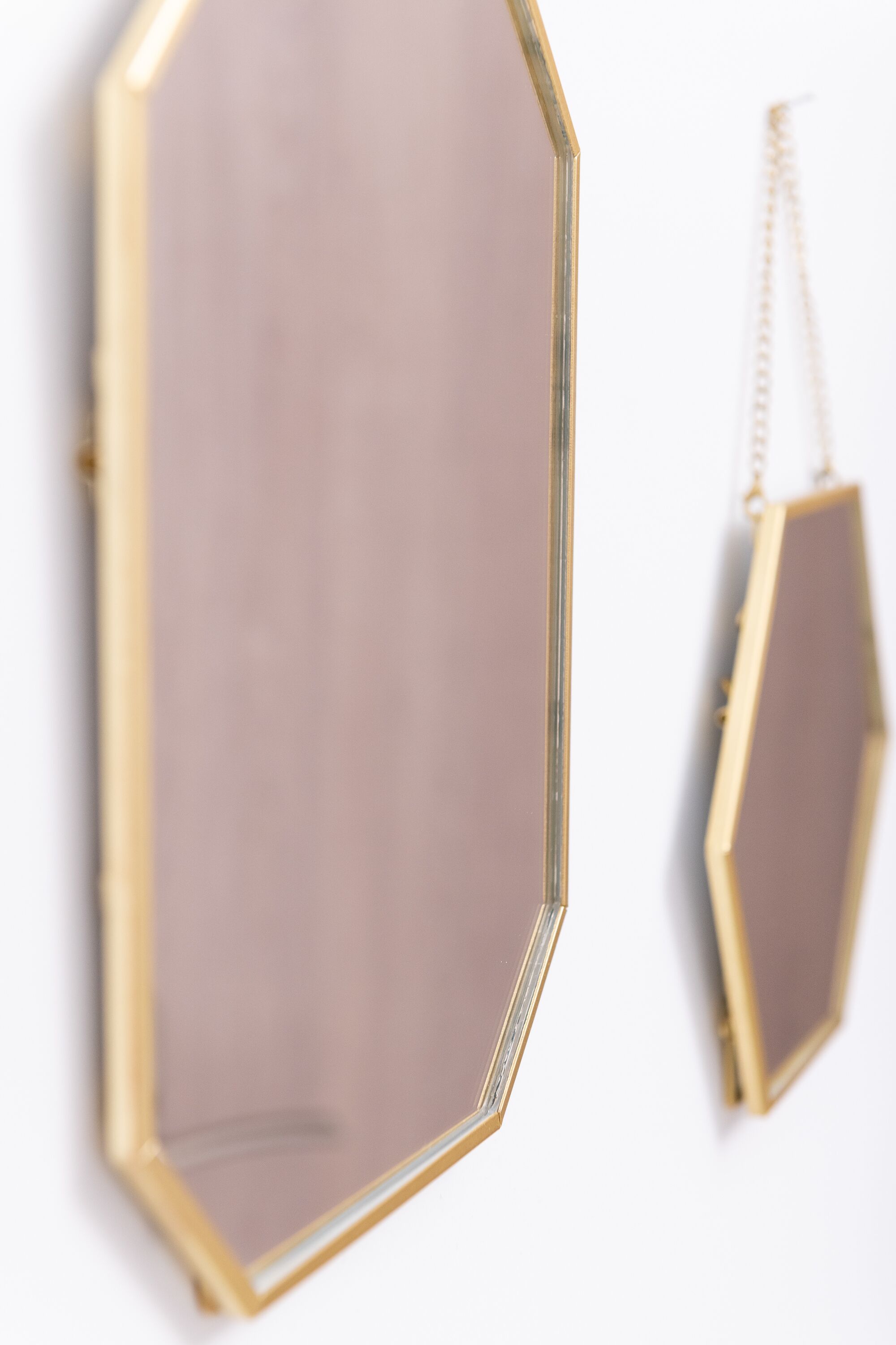 A geometric mirror with a gold frame.