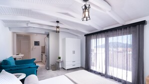 A modern hotel room with a large bed, a sofa, a desk, and a wardrobe. - Lithies Zante Living (Zakynthos)
