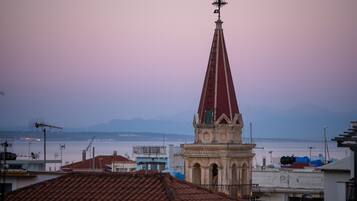 A church with a red spire, surrounded by buildings with red-tiled roofs.