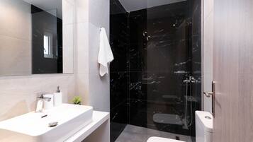 A modern bathroom with a white sink, a mirror, a glass shower enclosure, and a toilet.