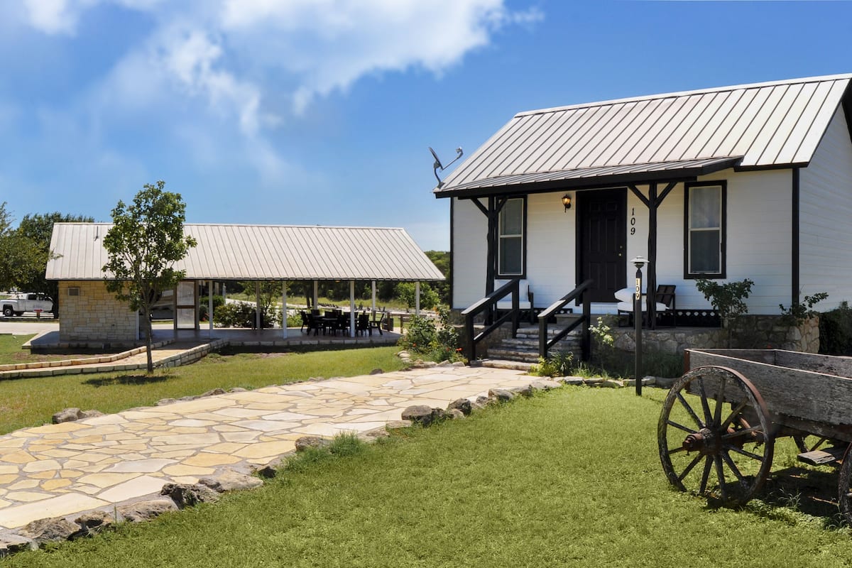 A historic building with a stone pathway leading to a wooden carriage.