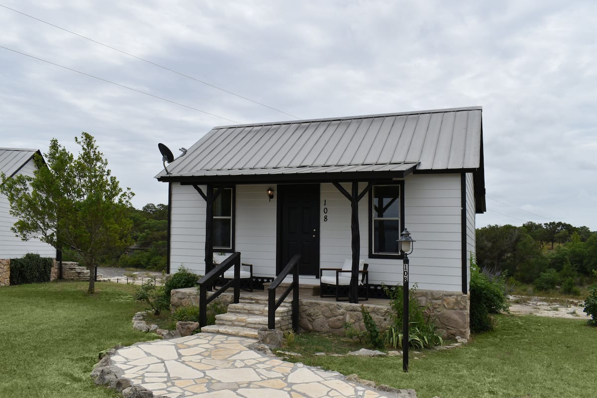 A small, single-story house with a stone pathway leading to the front door.