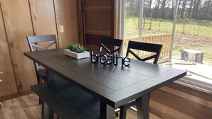 Et spisebord med stole, en plante og et skilt med teksten "breathe".