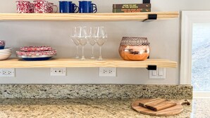 Una cocina con encimeras de granito, armarios de madera y lavavajillas integrado.