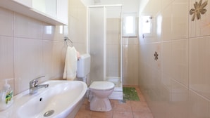 Ein Badezimmer mit Waschbecken, Toilette und Dusche.