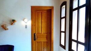 Una puerta de madera con manija, un suelo cubierto de alfombra azul y una silla morada.